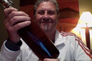 Woolley haired man waves a beer 